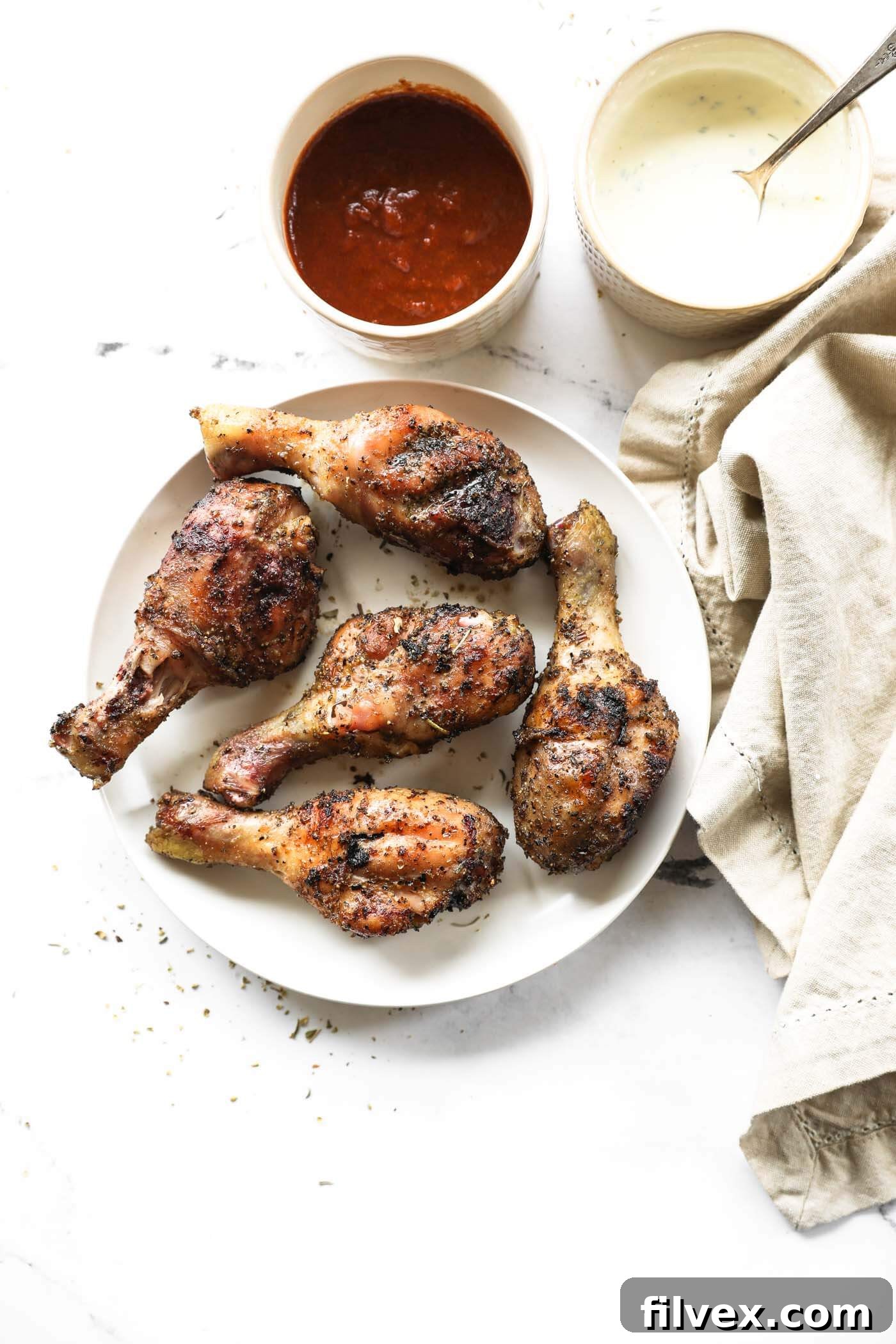 A beautifully plated serving of smoked chicken drumsticks, showcasing the crispy skin and juicy meat.