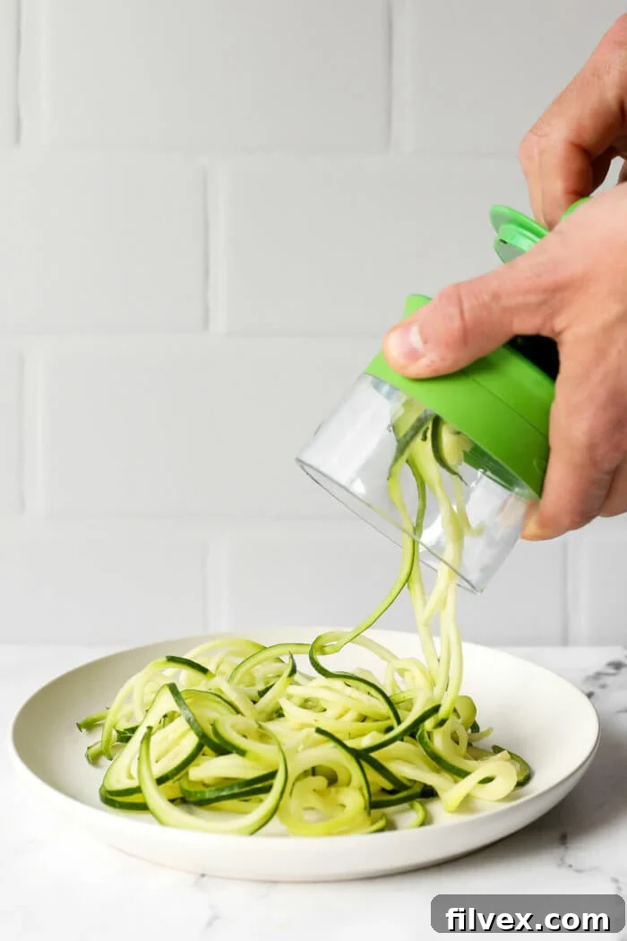 Image of making zucchini noodles with a handheld spiralizer.