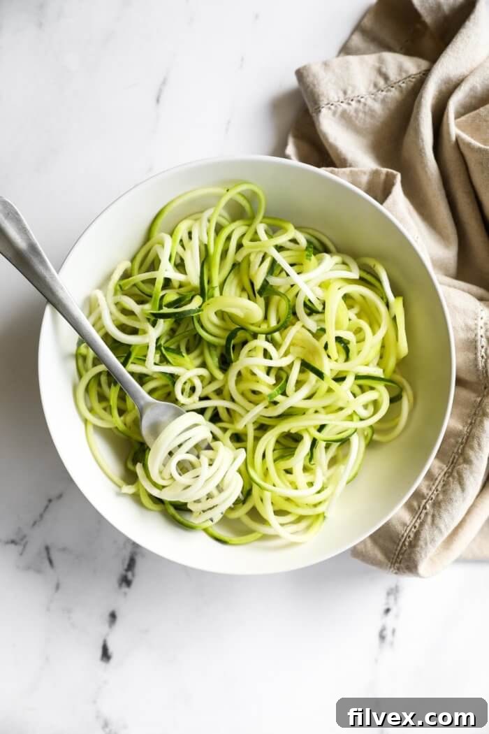 Overhead image of noodles in a bowl with a bite twirled around a fork.