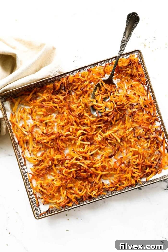 Air fryer basket filled with cooked, crispy shredded hash browns, ready to be served