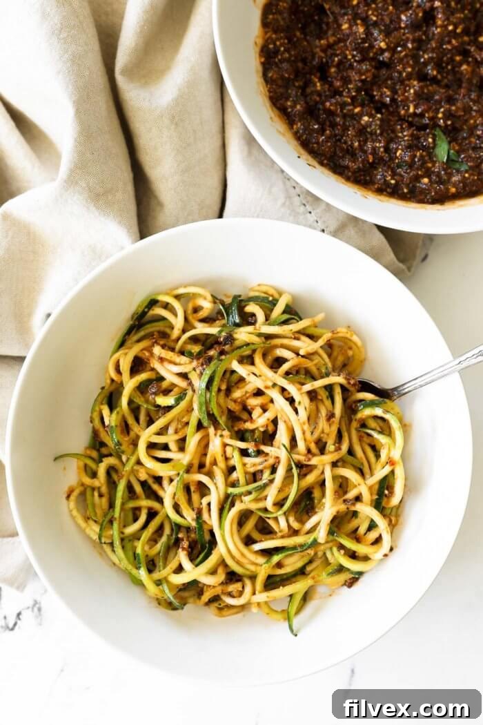Assortment of ingredients surrounding a bowl of homemade pesto rosso