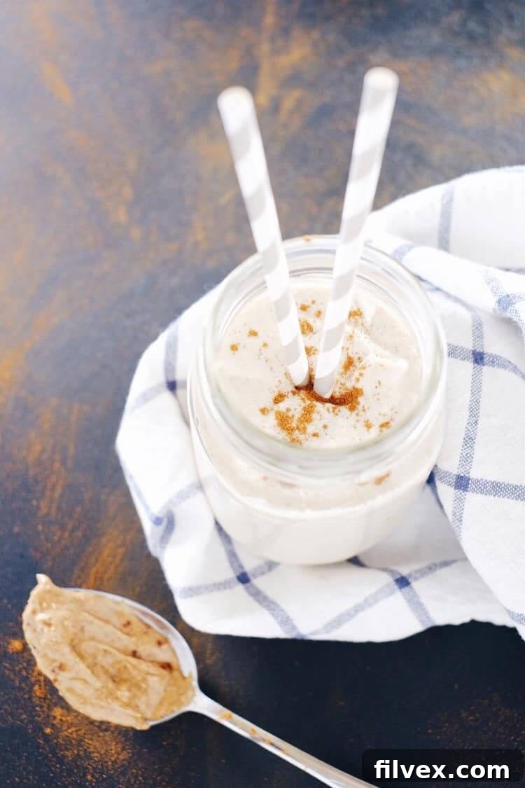A close-up shot of a banana almond butter smoothie in a clear glass, showing its smooth texture. This simple, four-ingredient blend is perfect for a Paleo, Gluten-Free, Dairy-Free, and Refined Sugar-Free diet.