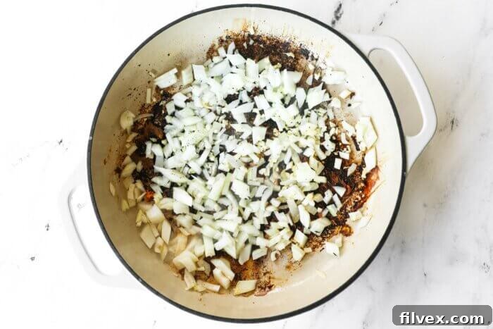 Diced onion and minced garlic added to a skillet.