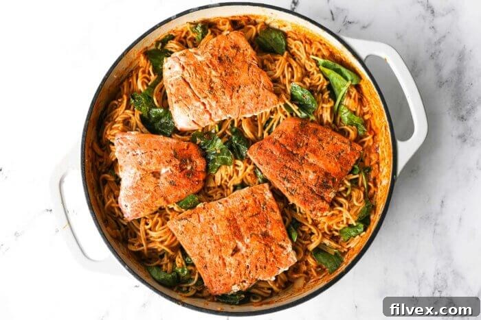 Cajun salmon pasta in a skillet once fully cooked. Pasta, salmon, spinach and a creamy cajun spiced sauce.