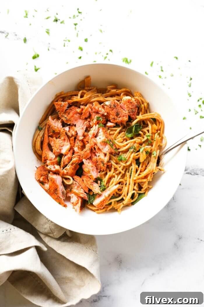 Cajun salmon shredded and served over creamy pasta in a bowl.