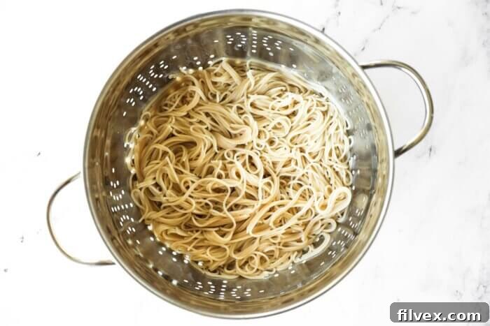 Cooked gluten free pasta in a colander.