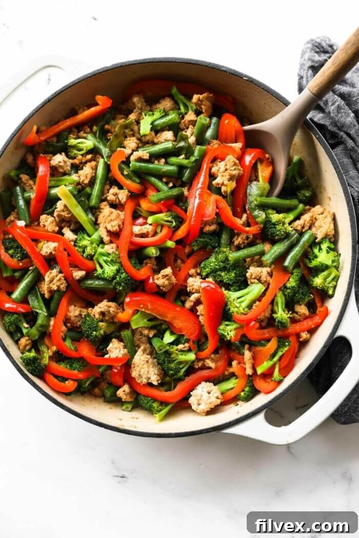 Close up overhead image of ground turkey teriyaki stir fry with vegetables in a pan