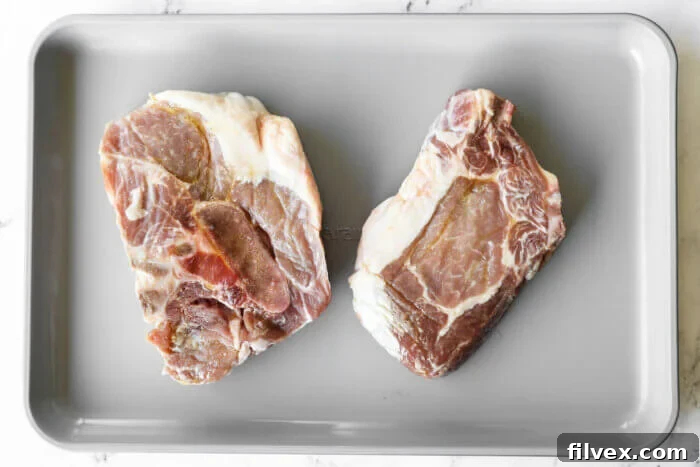 Uncooked pork chops on a baking sheet with oil on them