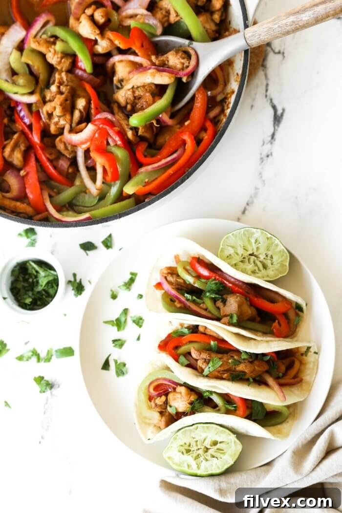 Sizzling chicken fajita mixture in a large cast iron skillet with fresh cilantro