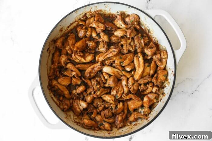 Chicken with fajita sauce in a skillet cooking