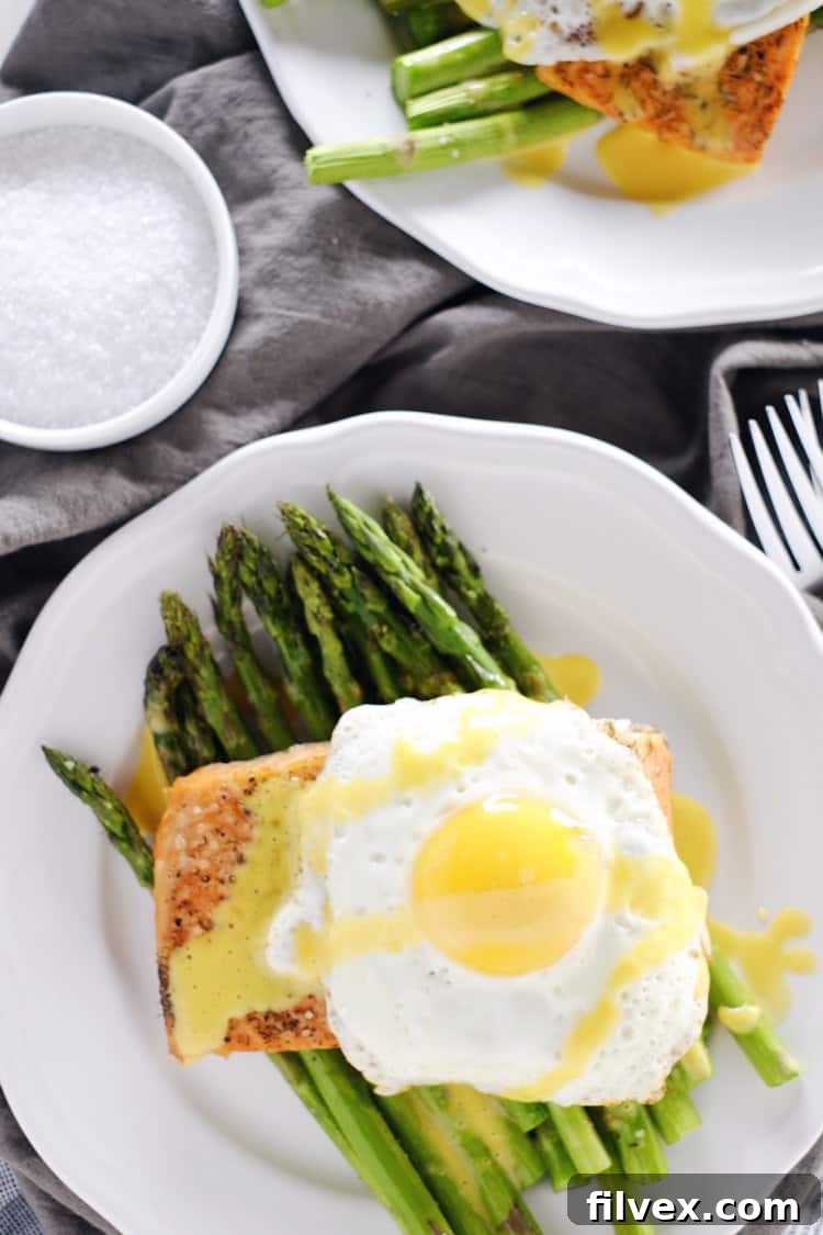 Perfectly roasted salmon and crisp asparagus, generously topped with creamy hollandaise sauce. A healthy and delicious Paleo, Whole30, and Keto-friendly meal from realsimplegood.com