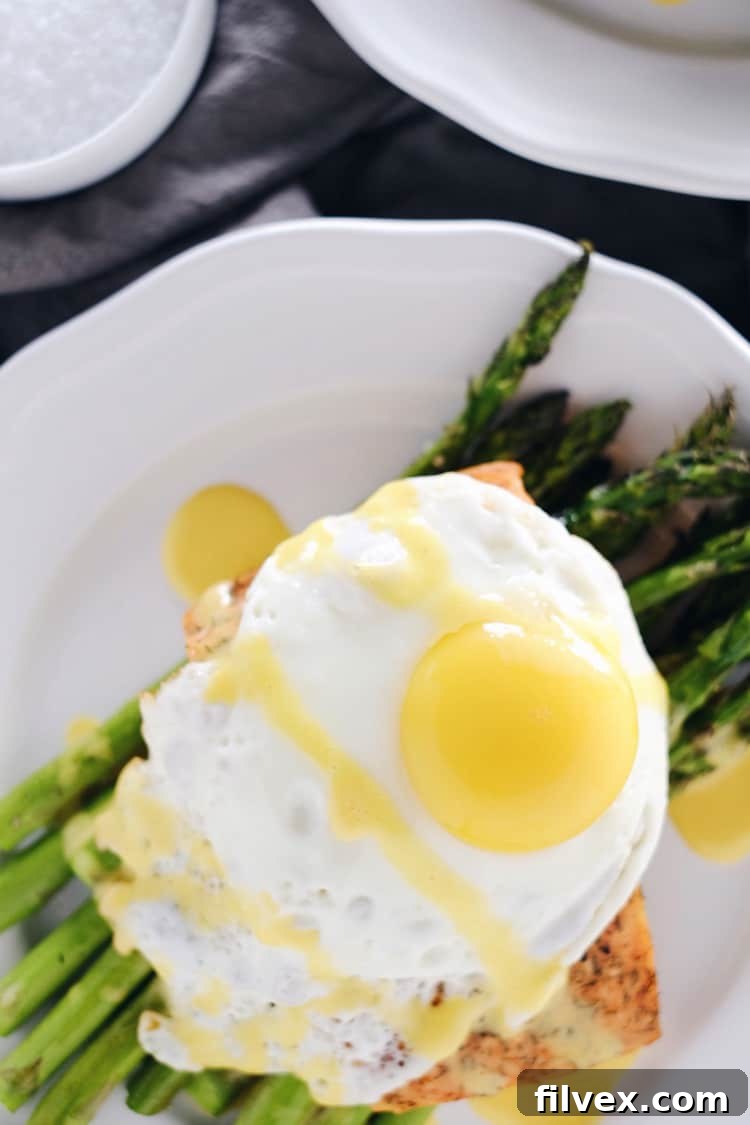 Delicious and healthy roasted salmon and asparagus with a rich hollandaise sauce. Expert tips for making this Paleo, Whole30, or Keto diet friendly recipe perfectly, by realsimplegood.com