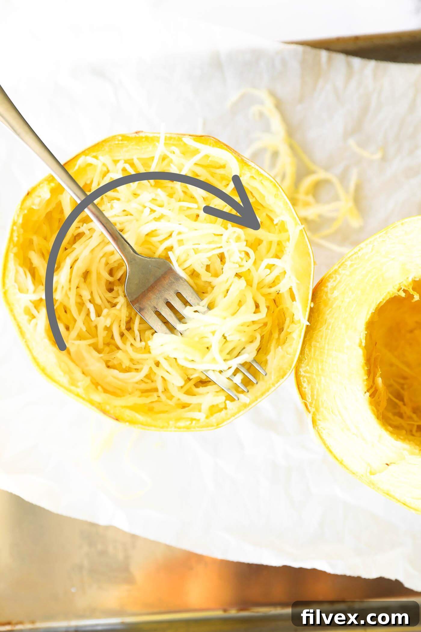 Cooked half of a spaghetti squash with noodles and an arrow showing which direction the noodles grow