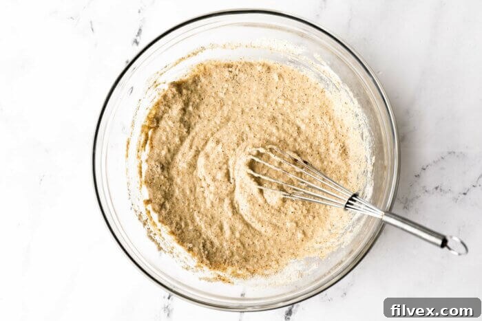 Wet ingredients whisked into the dry ingredients to make oat flour pancakes.
