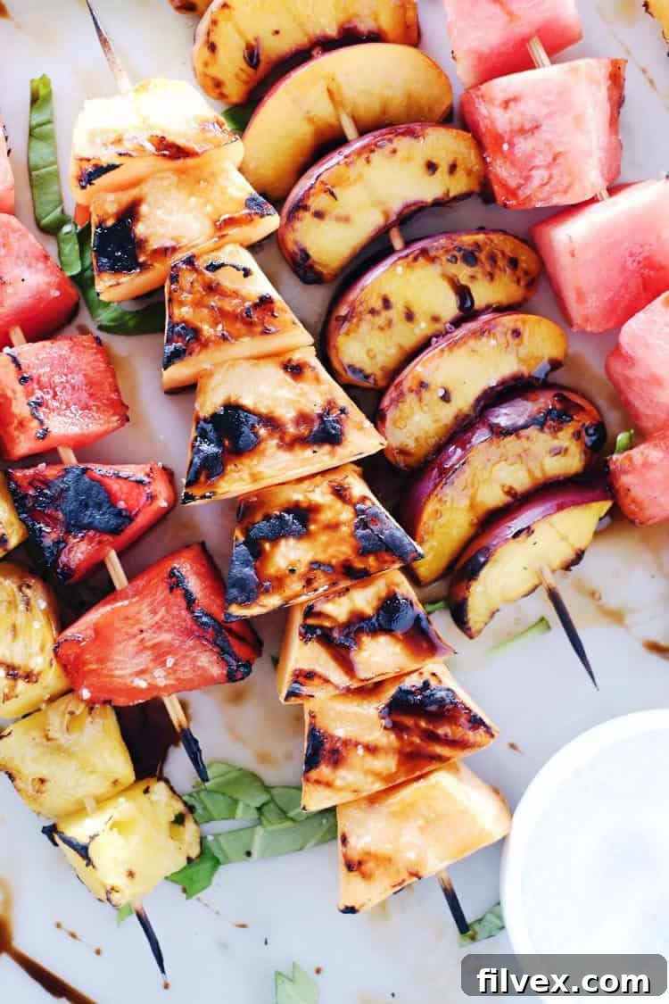 Assortment of grilled fruit kabobs on a wooden board, ready for serving.