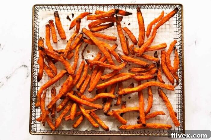 Cooked, crispy sweet potato fries inside the air fryer basket, ready to be served