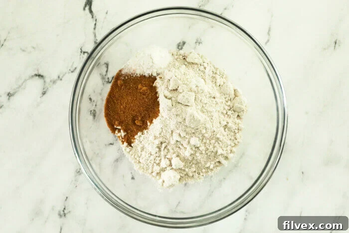 A mixing bowl with all of the dry ingredients to make oat flour waffles before whisking together.