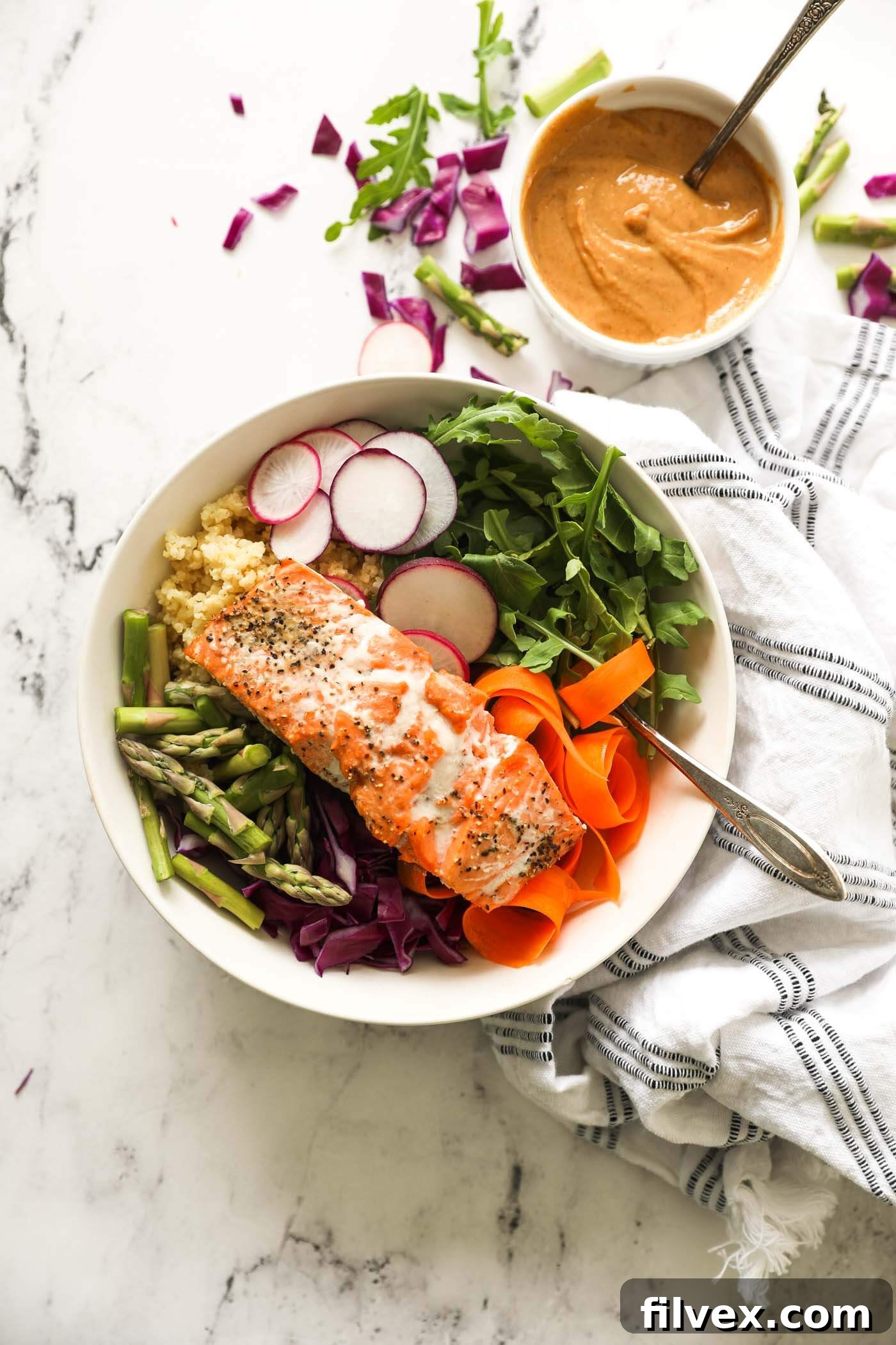 Ingredients for a salmon buddha bowl arranged neatly in separate sections within a bowl