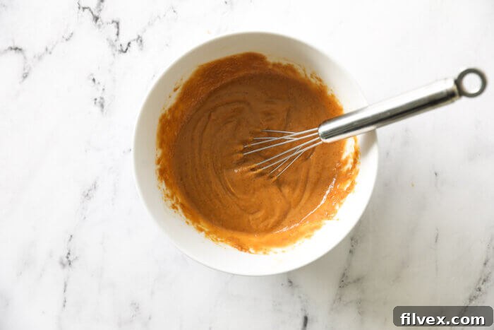 Peanut sauce in a ramekin with whisk poking out