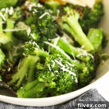 Close up of air fryer broccoli from frozen in a bowl, showing the perfectly crispy texture and seasonings.