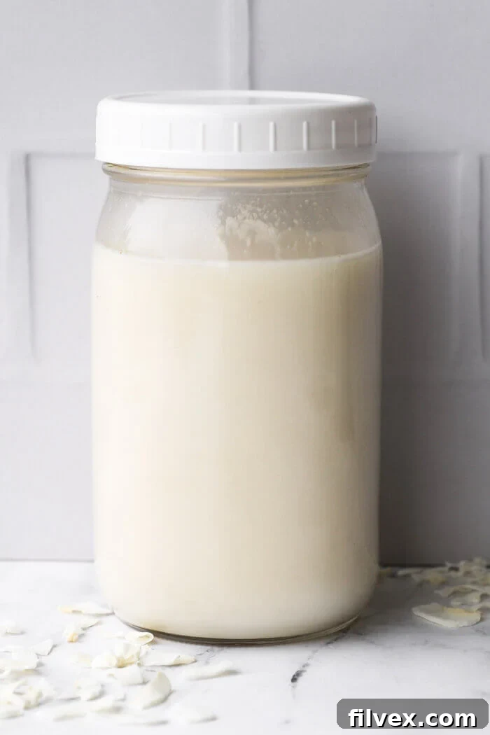 Coconut milk in a mason jar for storage with a plastic lid.