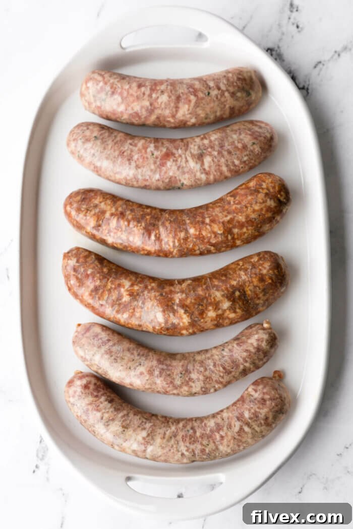 Uncooked sausage links resting on a cutting board, warming up to room temperature before smoking.