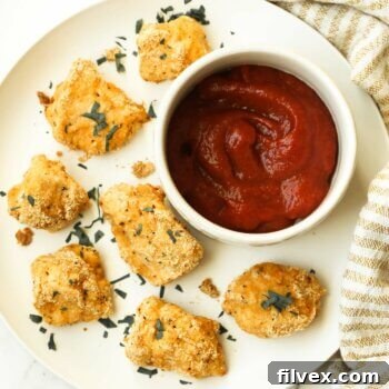 Crunchy keto chicken nuggets perfectly golden and crispy on a plate with ketchup