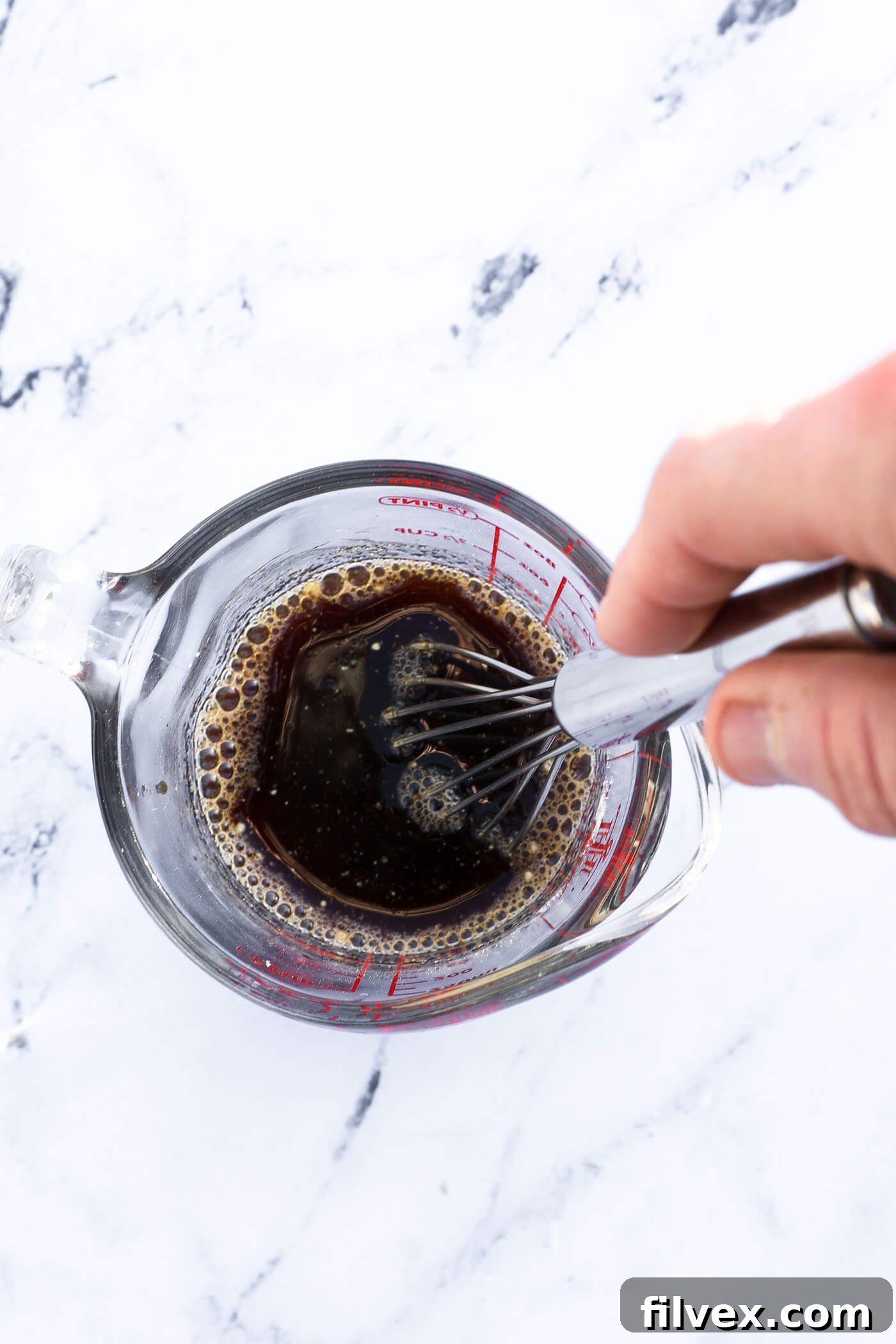 Ingredients for the salmon glaze being mixed together in a small bowl.