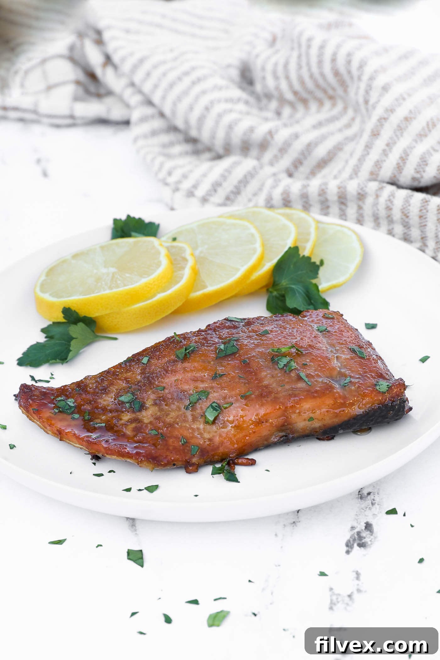 Close-up of a perfectly smoked salmon fillet with a glossy glaze, flaking easily.