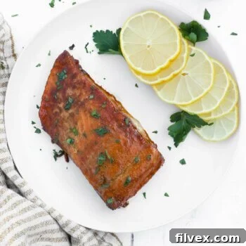 Overhead shot of smoked salmon with lemon wedges and chopped parsley