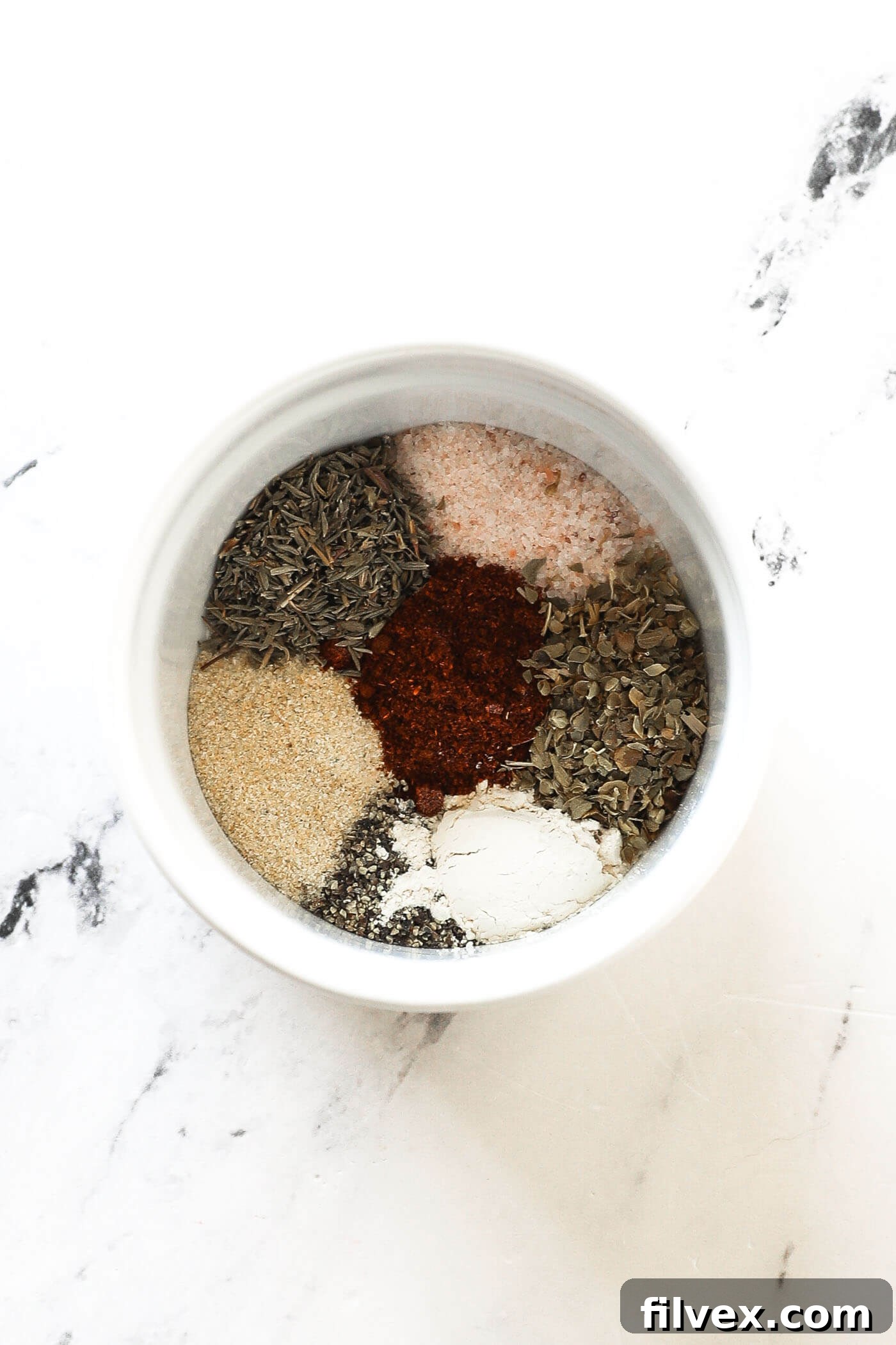 Mixing dry rub spices in a small bowl for chicken thighs