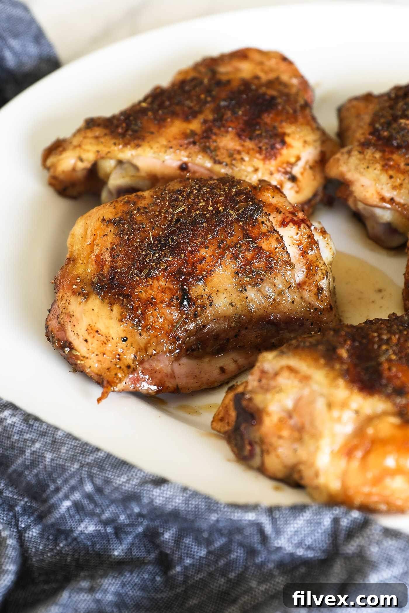 Close-up of crispy skin smoked chicken thighs with a perfectly rendered fat layer