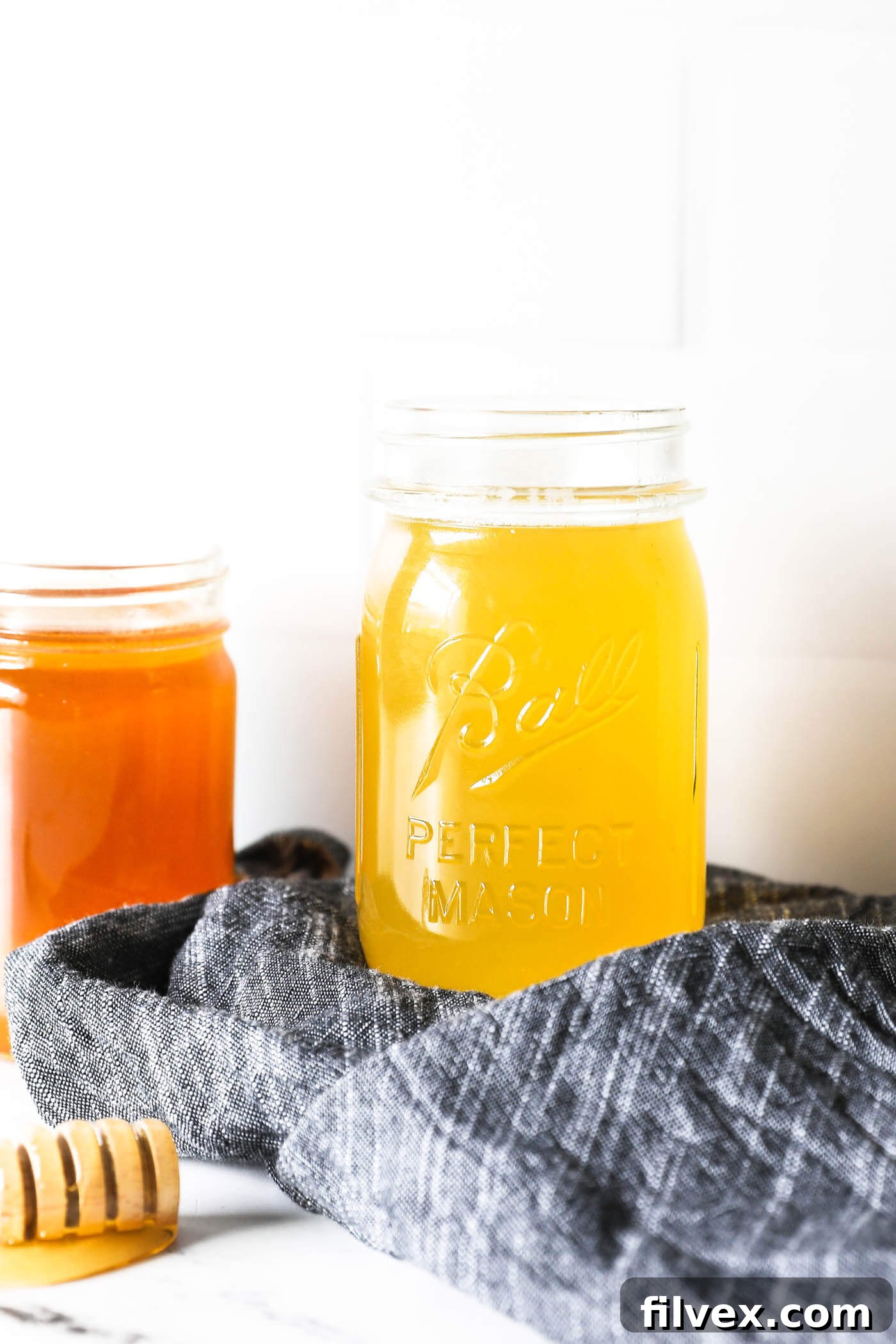 A jar of golden honey syrup, ready to be used as a natural sweetener.