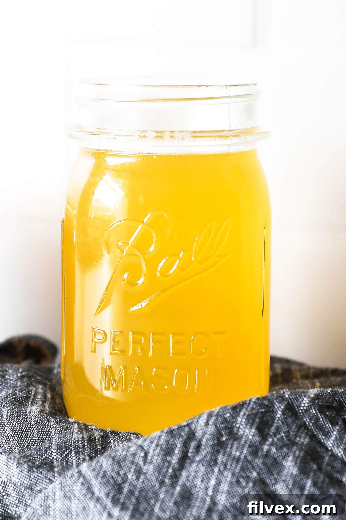 Close-up of infused honey syrup in a jar with rosemary sprigs.