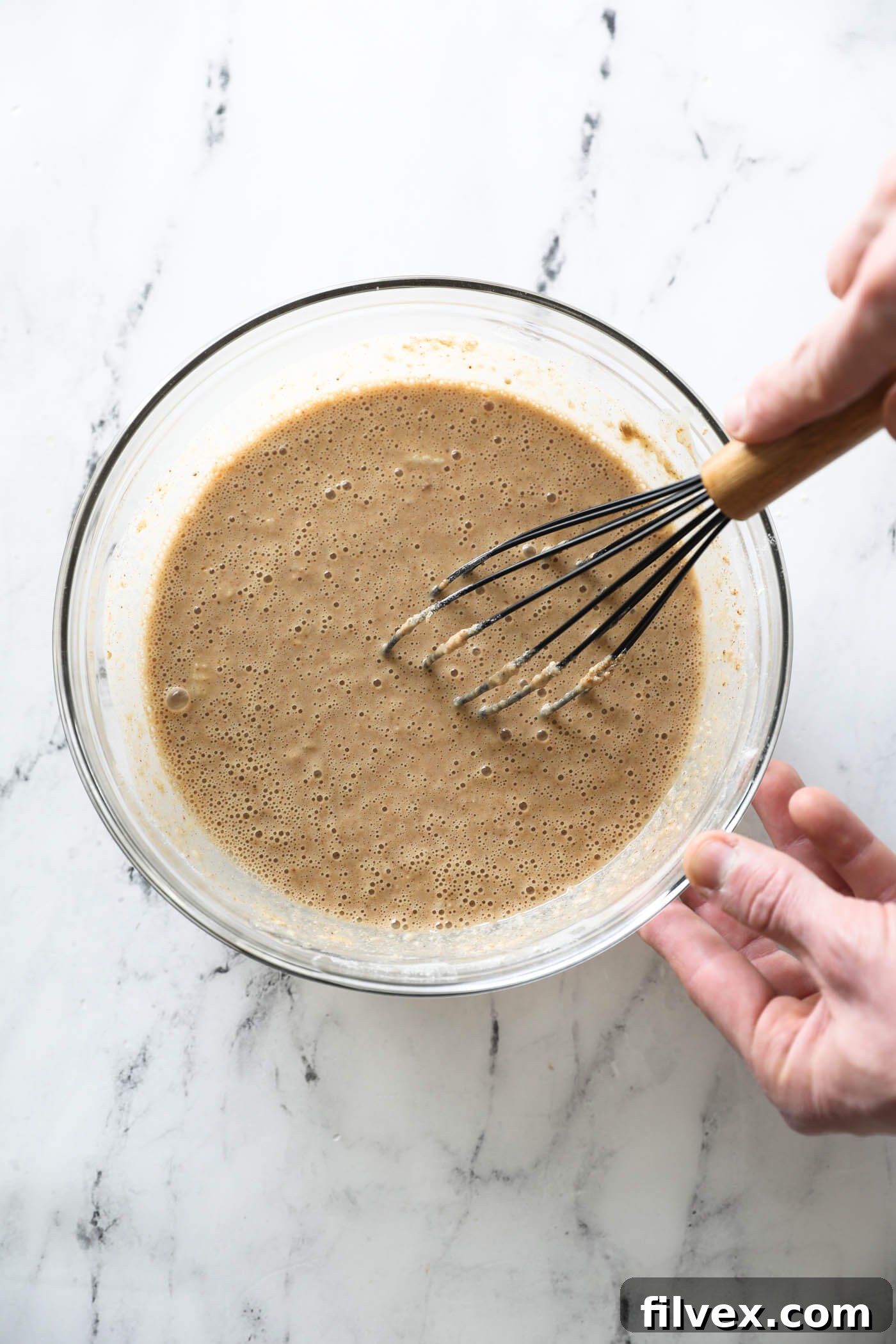 The zucchini bread batter whisked in a mixing bowl.