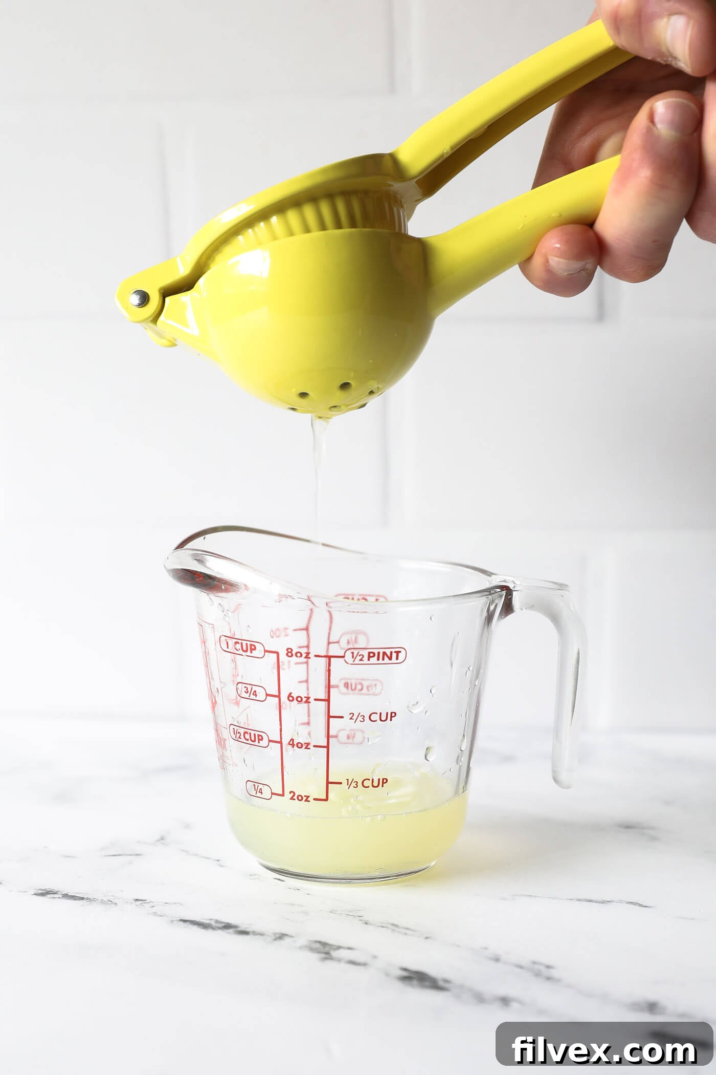 A hand squeezing fresh lime juice, emphasizing its importance.