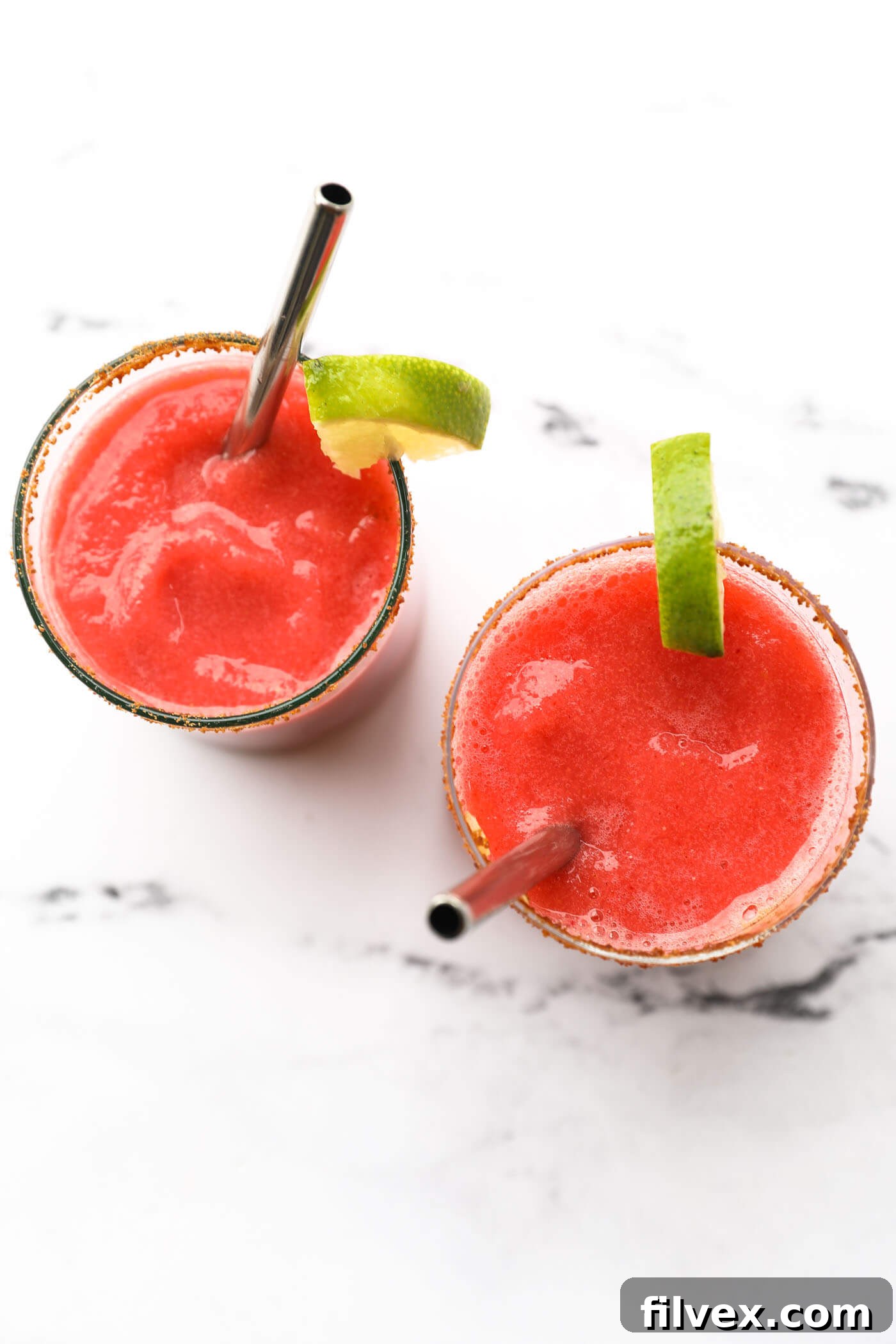 Close-up of a frosted glass filled with frozen strawberry daiquiri mocktail, showing its vibrant color and smooth texture.