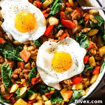 A close-up of a delicious chorizo hash with fried eggs, ready to eat.