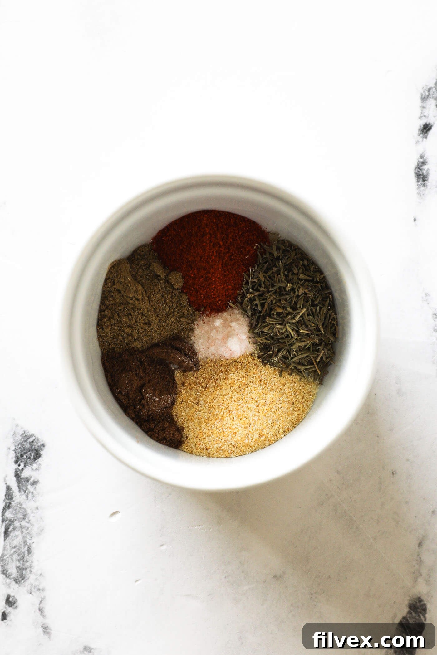 Mixing salmon seasoning spices in a small bowl with a spoon