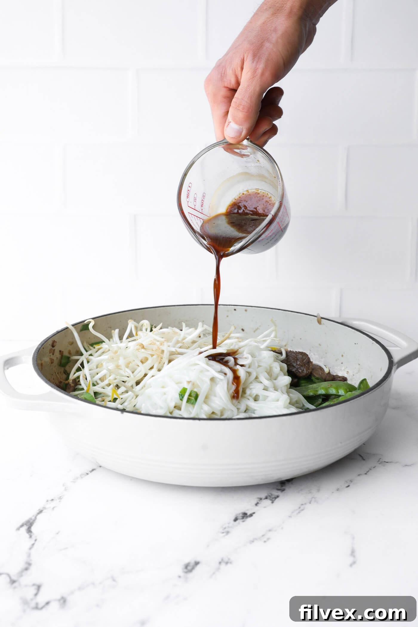 Cooked rice noodles and fresh bean sprouts are tossed into the skillet, ready to be coated with the delicious Pad Thai sauce.