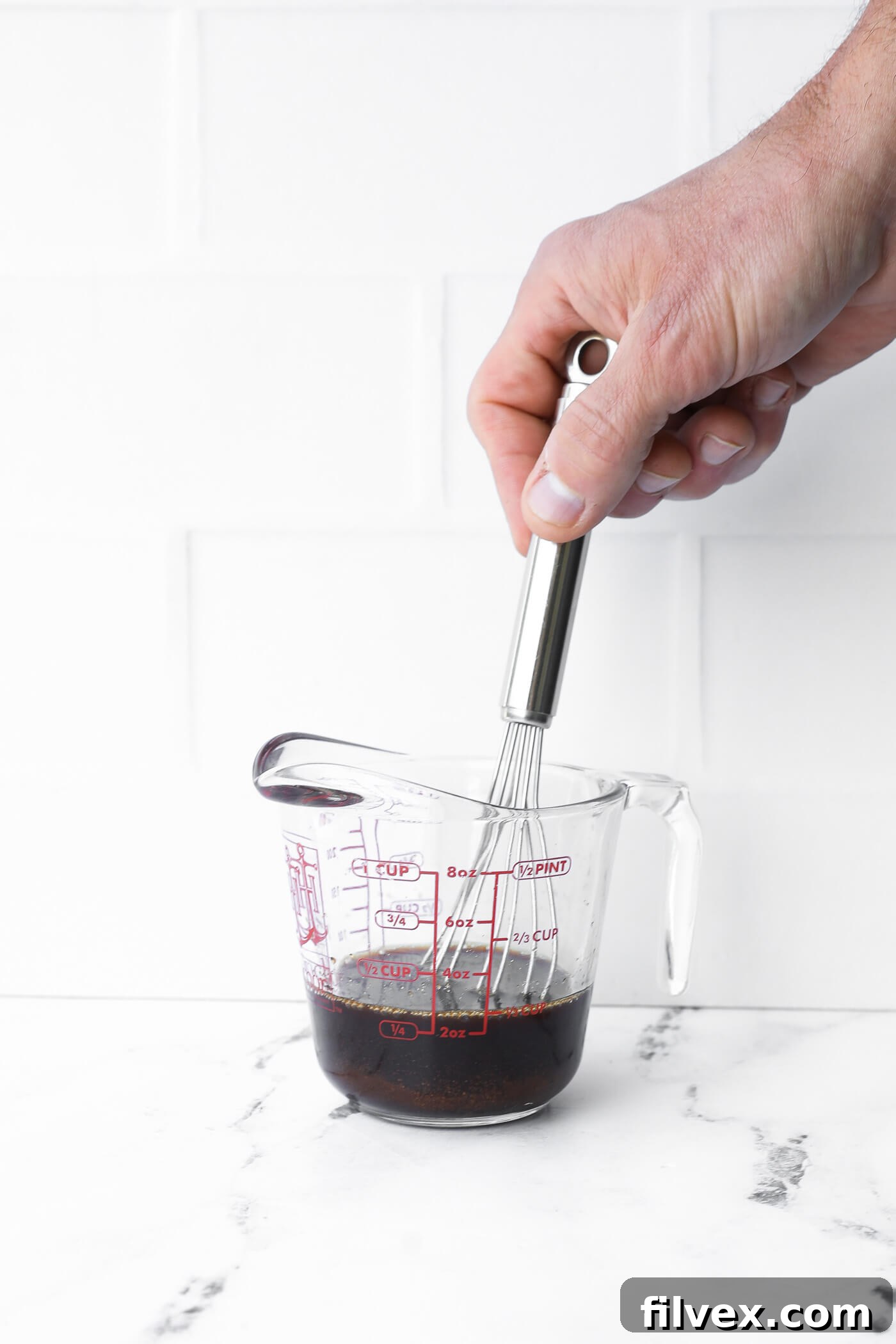 All four simple ingredients for the Pad Thai sauce are mixed thoroughly in a small bowl, ready to be poured over the noodles.