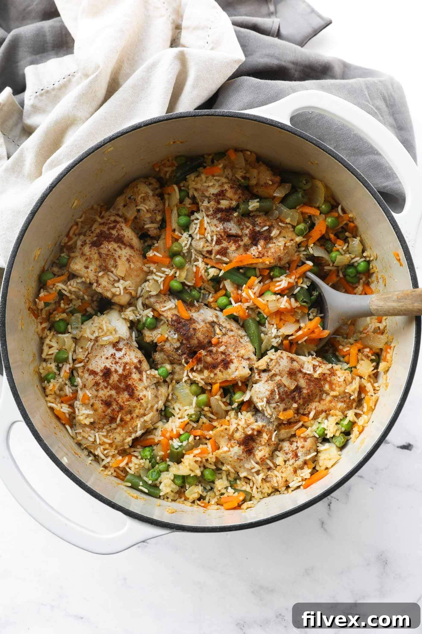 A beautifully cooked Dutch oven chicken and rice dish, garnished and ready to serve.