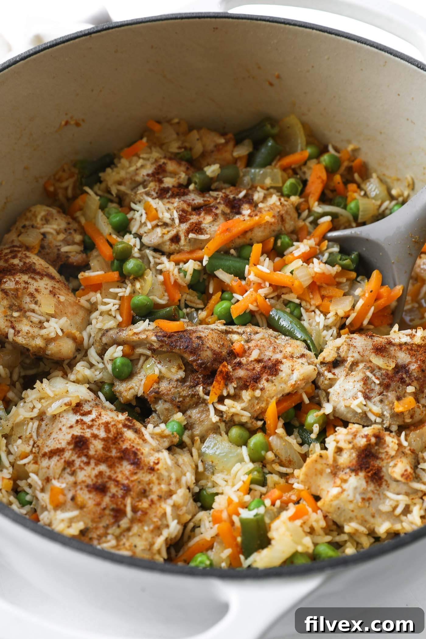 A close-up shot of the cooked Dutch oven chicken and rice, showcasing its tender chicken and perfectly cooked grains.