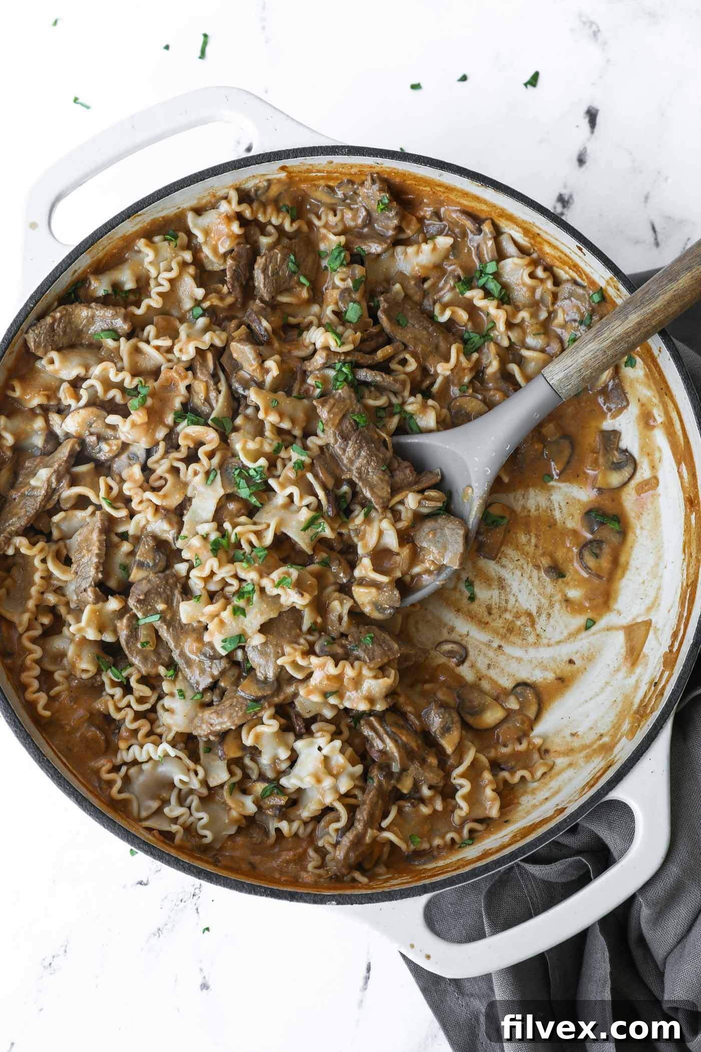 A vibrant close-up of the 30-Minute Creamy Beef and Mushroom Skillet, showcasing tender beef strips, sliced mushrooms, and a rich, creamy sauce in a rustic pan, garnished with fresh parsley.