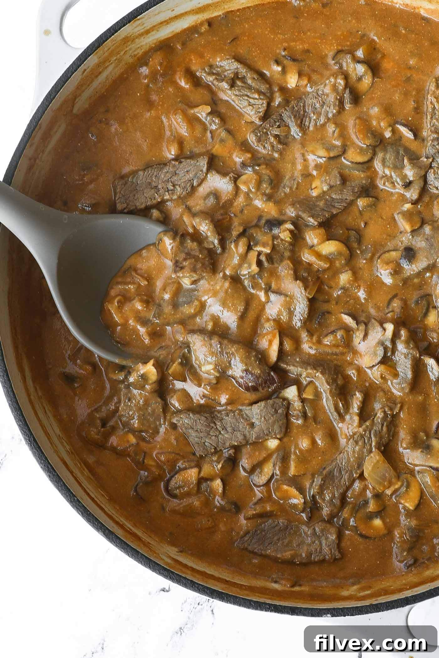 A close-up overhead shot of the finished 30-Minute Creamy Beef and Mushroom Skillet, garnished with fresh herbs, showcasing its rich texture and appetizing appearance.