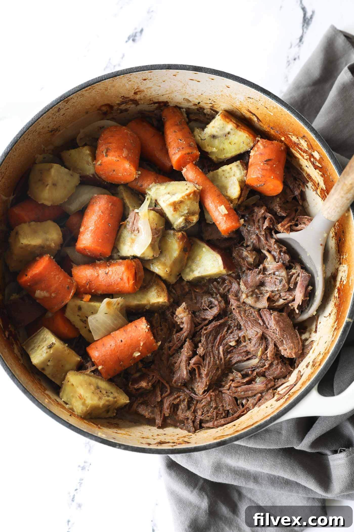 Delicious Dutch Oven Pot Roast with shredded beef, carrots, and potatoes