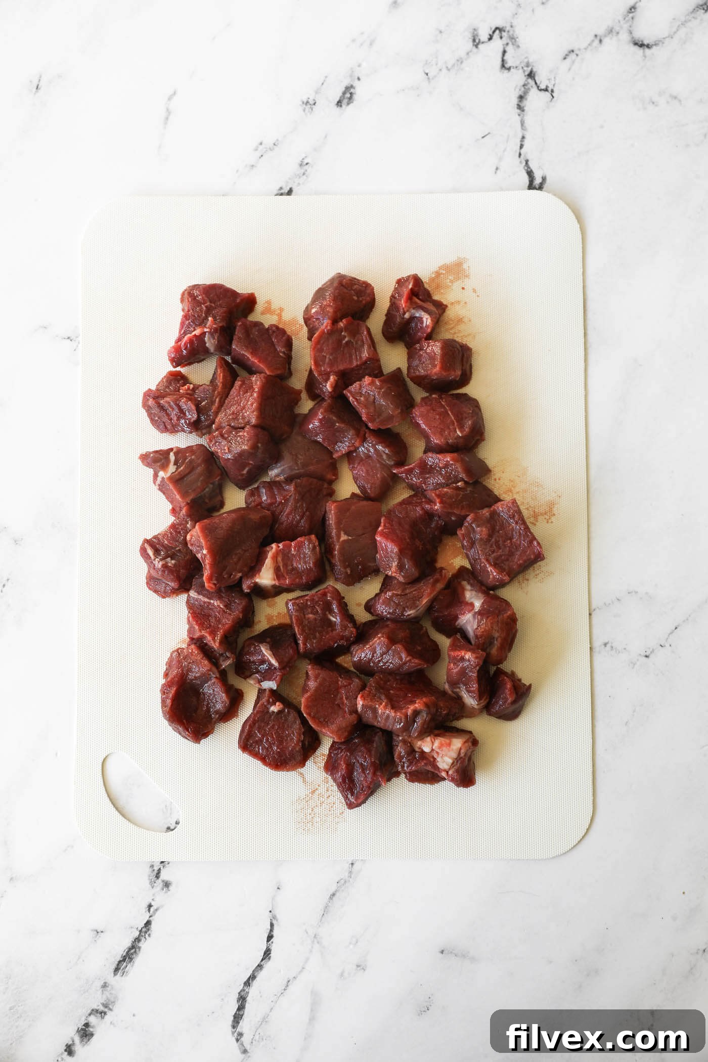 Cutting beef into uniform cubes for the stew.