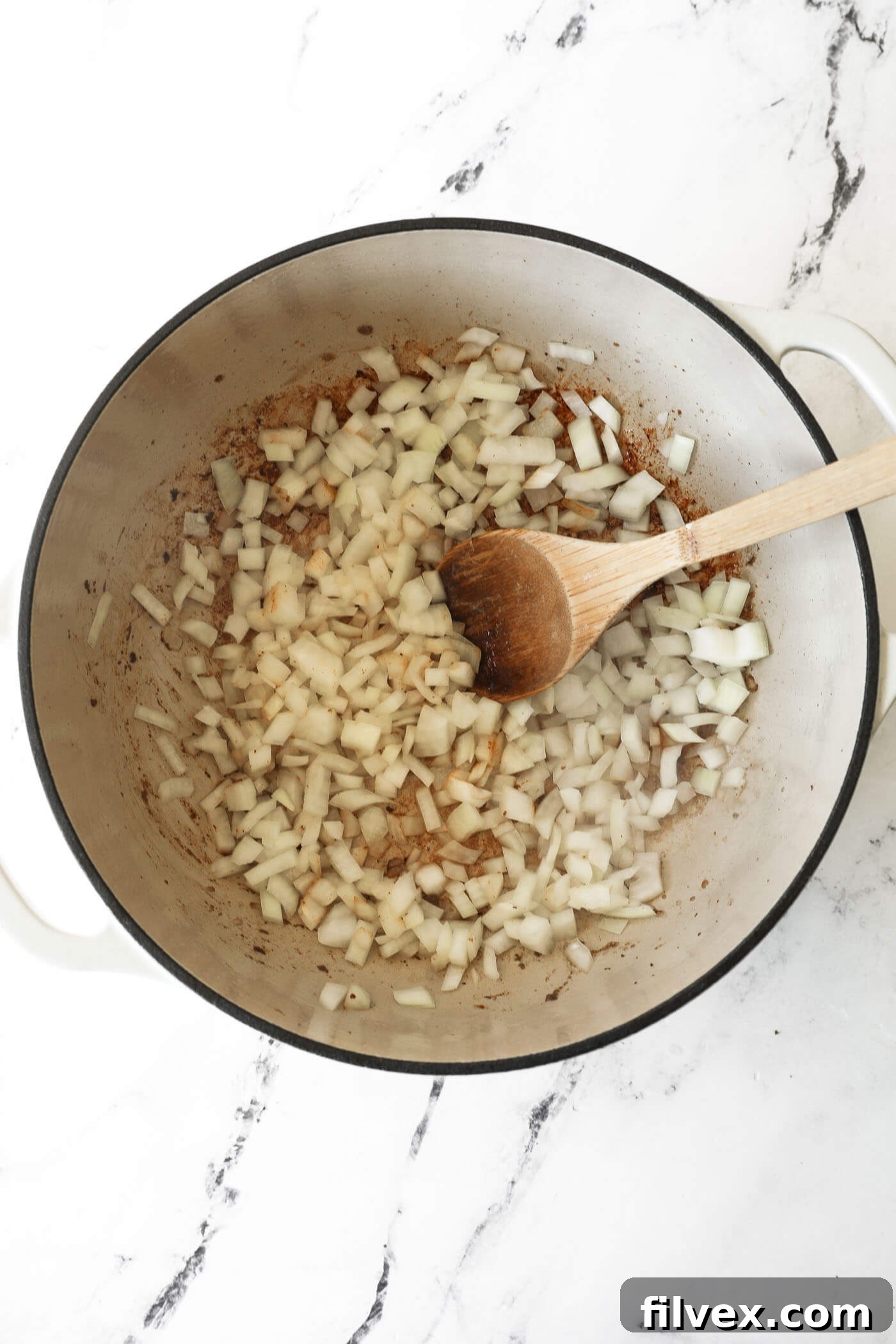 Cooking diced onions in a Dutch oven until softened.