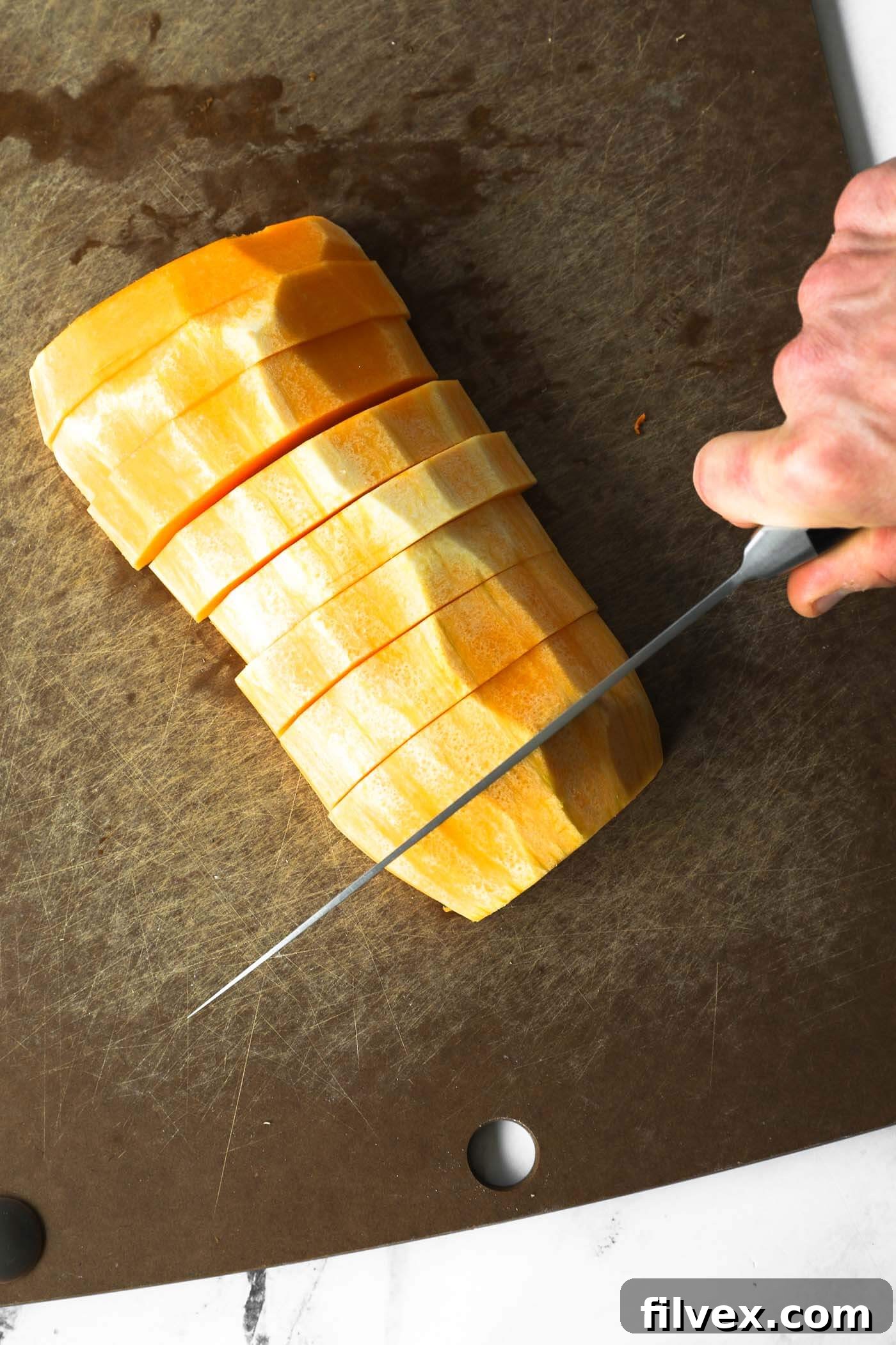Cutting the deseeded butternut squash into strips.