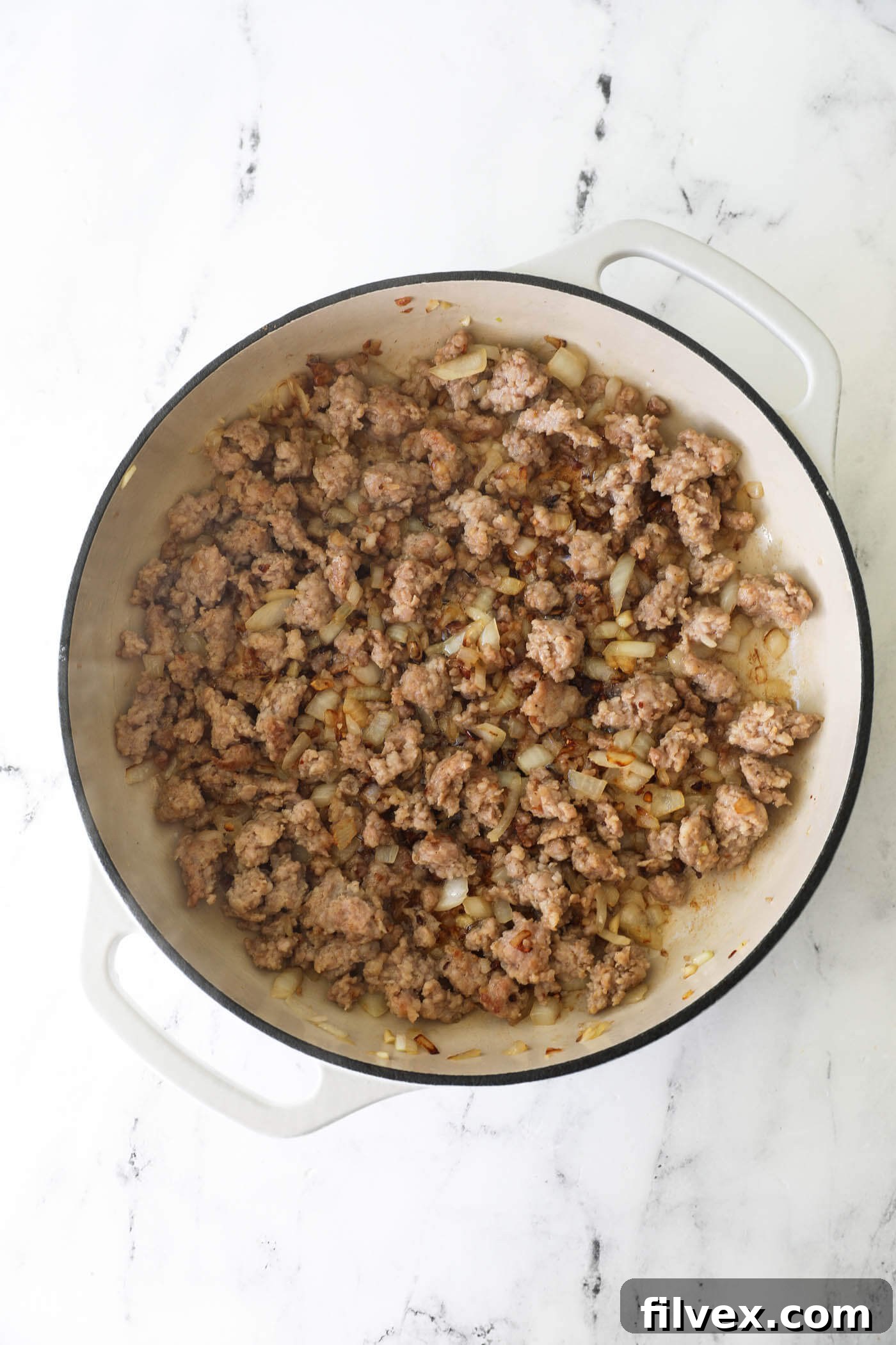 Step 4: Ground pork browning in a skillet, being broken into smaller pieces.